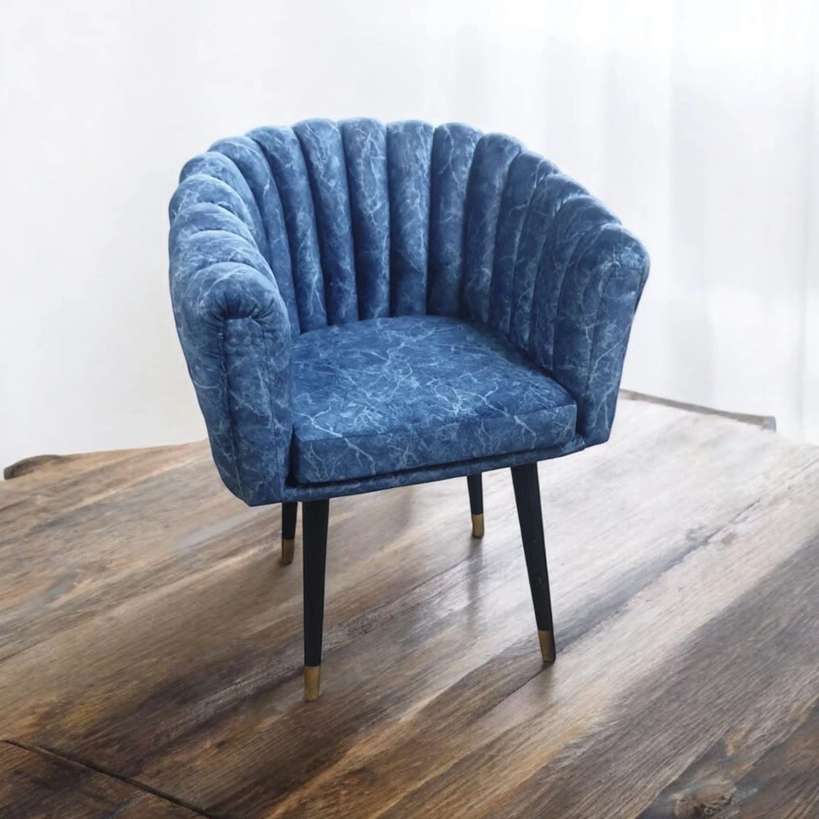 scallop-shaped chair in marbled blue velvet